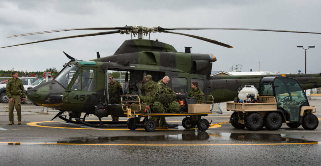 Canadian Armed Forces members unload a CH-147 helicopter from 1 Wing 408 Tactical Helicopter Squadron from Canadian Forces Base Edmonton, Alta., during Operation Nanook at Erik Nielsen Airport in Whitehorse, Yukon. Cpl Chase Miller Photo