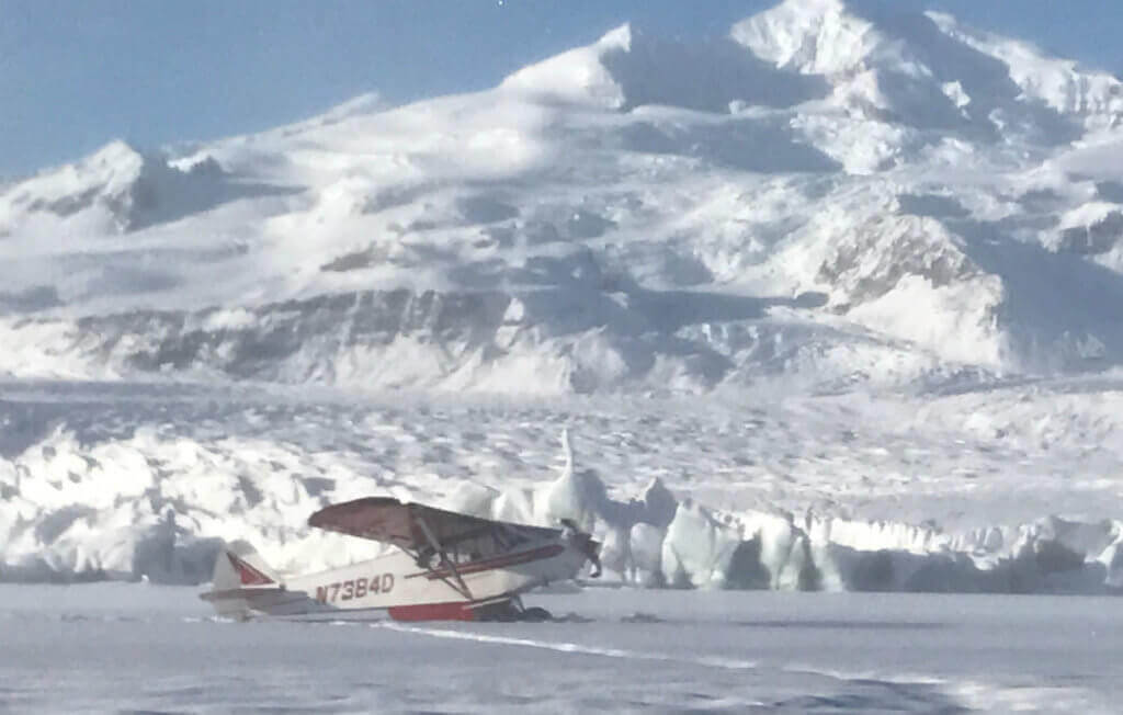 A plane rests on a frozen lake after a crash-landing in deep snow near Shelikof Strait, Alaska, Jan. 22, 2017. The pilot was hoisted and transported, with no apparent injuries, to Kodiak by a Coast Guard Air Station Kodiak MH-60 Jayhawk helicopter crew.