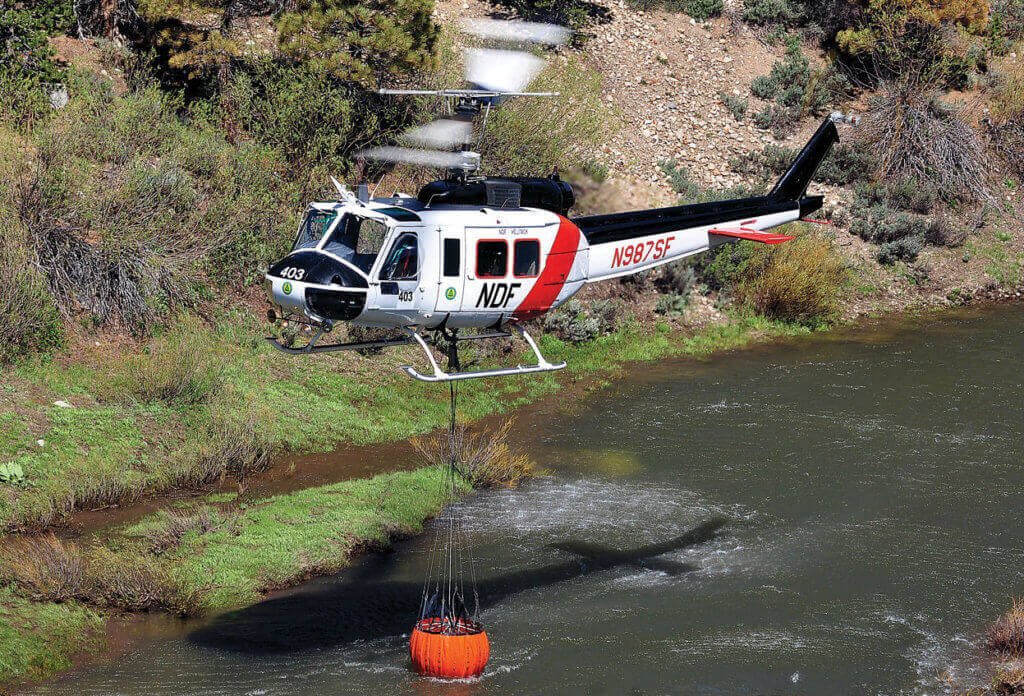 Rivers, lakes and any other water source will be utilized during a fire. Here, the Super Huey lifts a full load of water from a flowing river.