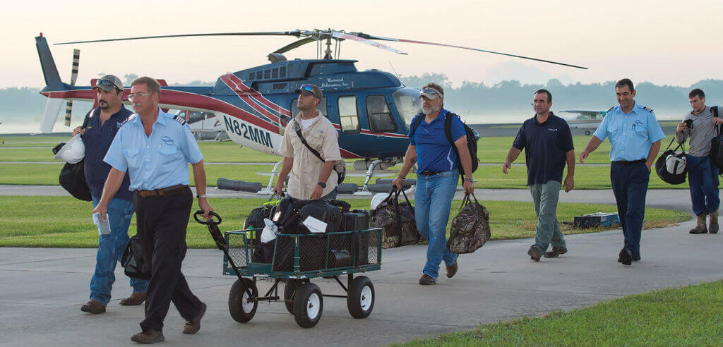 Pilot Doug Greenwald escorts his passengers to the aircraft for a morning flight from the Abbeville base. This facility handles the majority of the company's crew shuttles to and from offshore platforms.