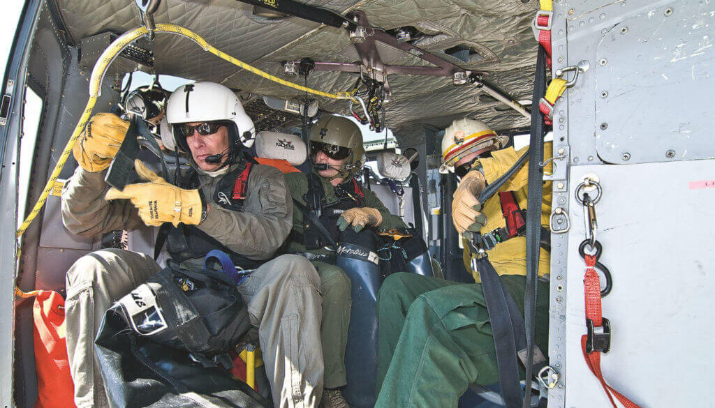 Rangers Jack Hoe flich and Chris Bellino, with spotter Boots Davenport, ready the cabin for heli-rappel training out of Yosemite's helibase at Crane Flat.