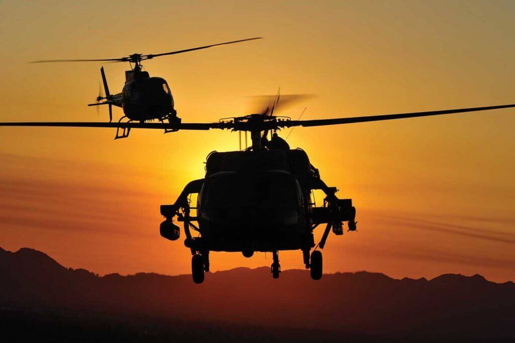 The Movie Hawk is chased by an Airbus AS350 B2 camera ship as the sun sets over Los Angeles.