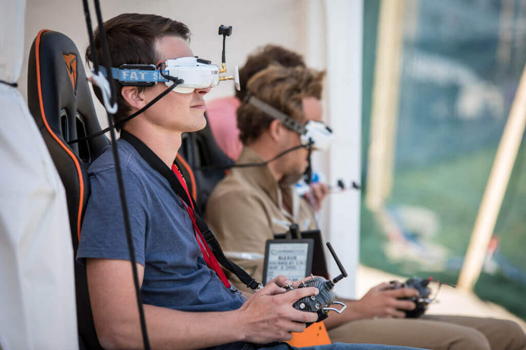Droner racers wear immersive headsets that give the user a first-person view from the drone as fly around a course. FAI Photo