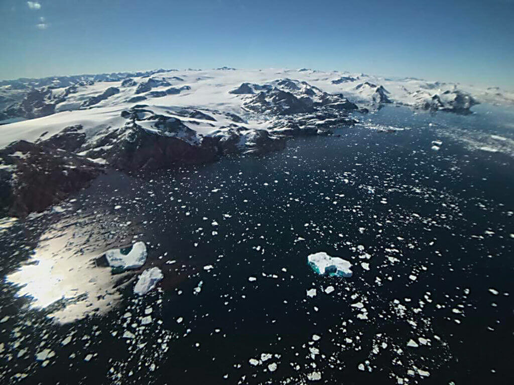 View of water and snow-capped mountains in Greenland.