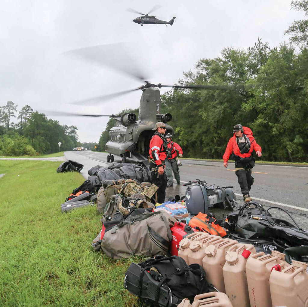Alaska and California Air National Guardsmen unload search-and-rescue equipment from a Texas Army National Guard CH-47 Chinook helicopter from the 2-149th General Support Aviation Battalion. 