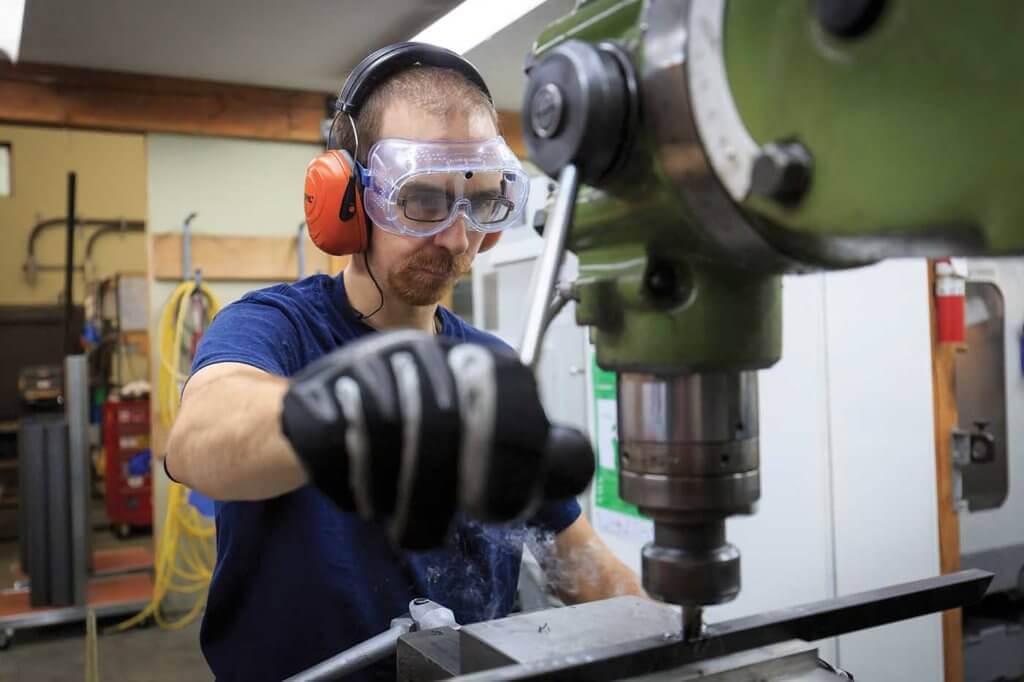 Doug Hammer operates a drill press.