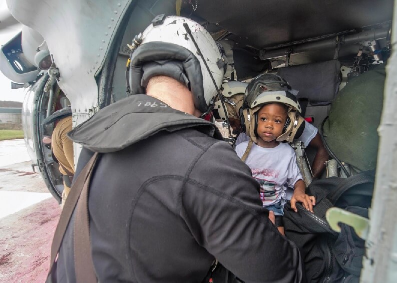 Naval Aircrewman (Helicopter) 2 nd Class Logan Parkinson, assigned to Helicopter Sea Combat Squadron (HSC) 22, prepares a patient's family for evacuation during relief efforts in the wake of Hurricane Maria in the U.S. Virgin Islands, Sept. 21. U.S. Navy MC3 Levingston Lewis Photo