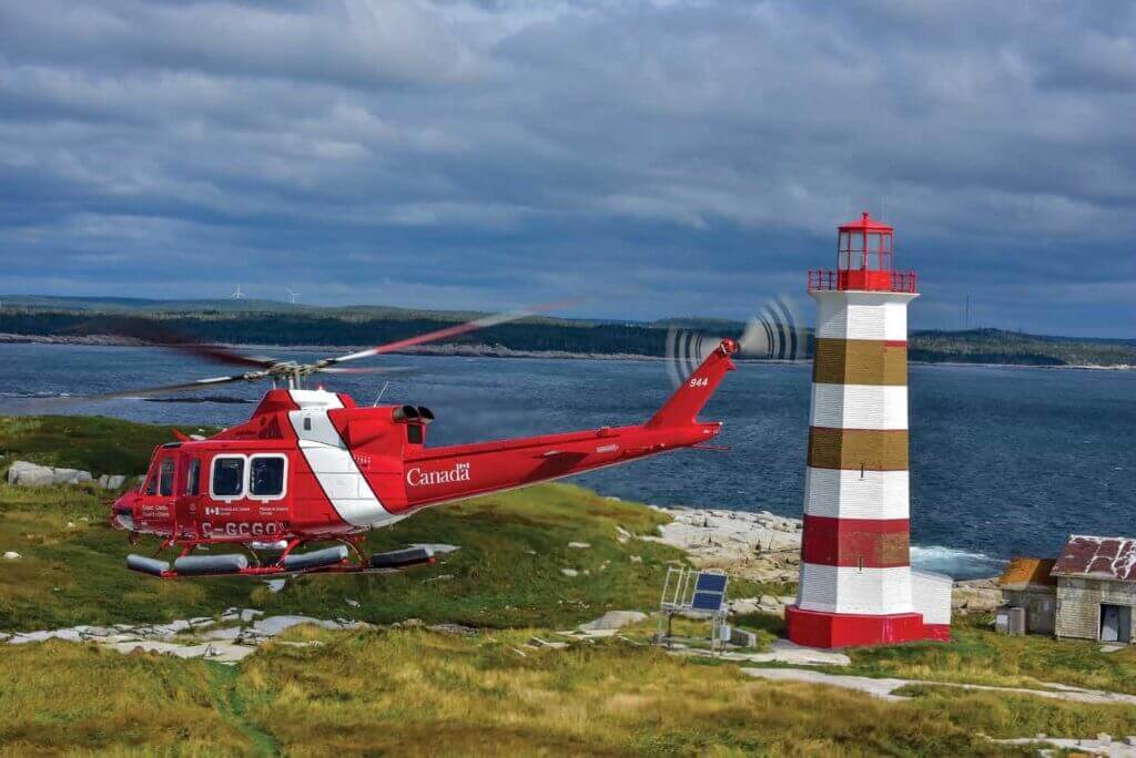 A Canadian Coast Guard Bell 412EPI holds a hover in front of a lighthouse off the coast of Halifax, Nova Scotia. The agency recently renewed its entire fleet of 22 aircraft. Mike Reyno Photo