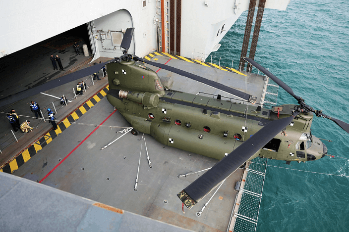 With the nose protruding over the edge of one of HMS Queen Elizabeth's two mighty aircraft lifts, the 99-foot helicopter from RAF 7 Squadron was moved from the flight to the hangar deck.
