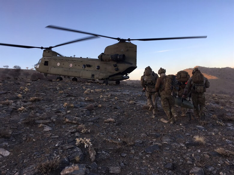 Members of the 83rd Expeditionary Rescue Squadron prepare to board a U.S. Army CH-47 Chinook at an undisclosed location in Afghanistan.