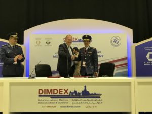 CAE's Ian Bell (left) and an officer from the Qatar Emiri Air Force celebrate the signing of comprehensive NH90 program at DIMDEX 2018. CAE Photo