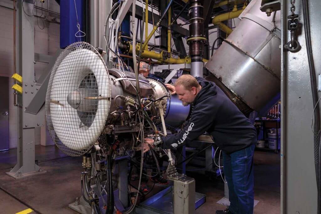 John Chergosky connects test leads to one of the S-64's P&WC JFTD12A turboshaft engines in Erickson's engine test cell. Heath Moffatt Photo 