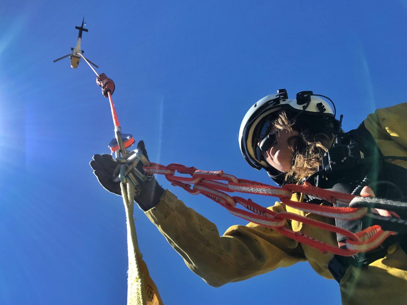 A Forest Service short-hauler prepares to be lifted by a helicopter