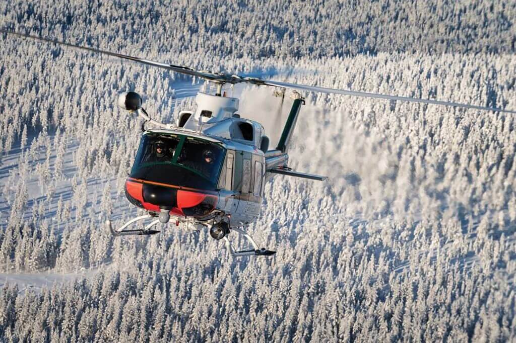 Exhaust pours from the engines of a Finnish Border Guard Bell 412 as its crew flies above the most dominant features of Rovaniemi landscape, snow and trees. Lloyd Horgan Photo