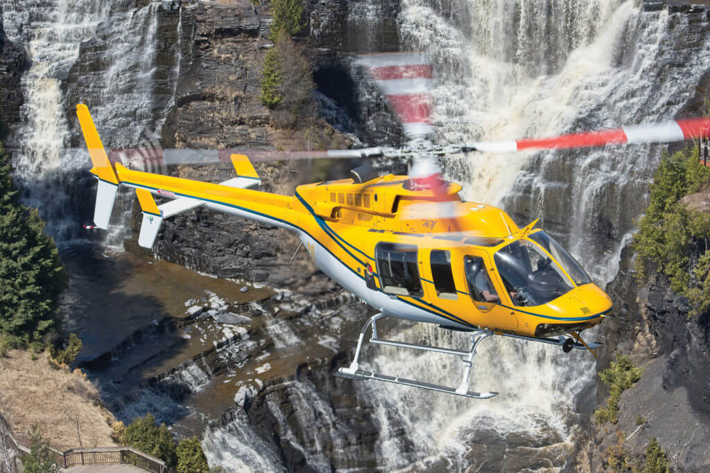 A Bell 407 holds a hover in front of the Kakabeka Falls near Thunder Bay, Ontario. Boreal forest with rivers, rocks and waterfalls cover much of the region. Mike Reyno Photo