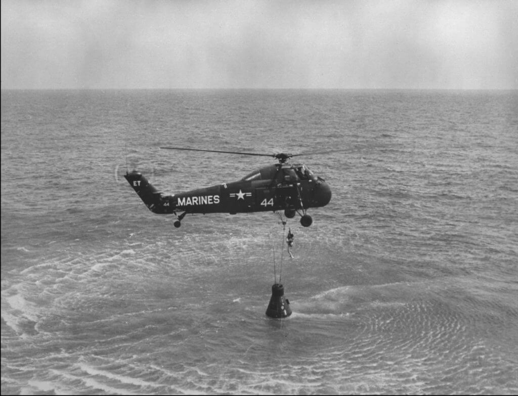 NASA Astronaut Alan B. Sheppard Jr. is hoisted up in a body harness by a U.S. Marin Corps helicopter recovery team following the first Project Mercury suborbital space flight. NASA Photo