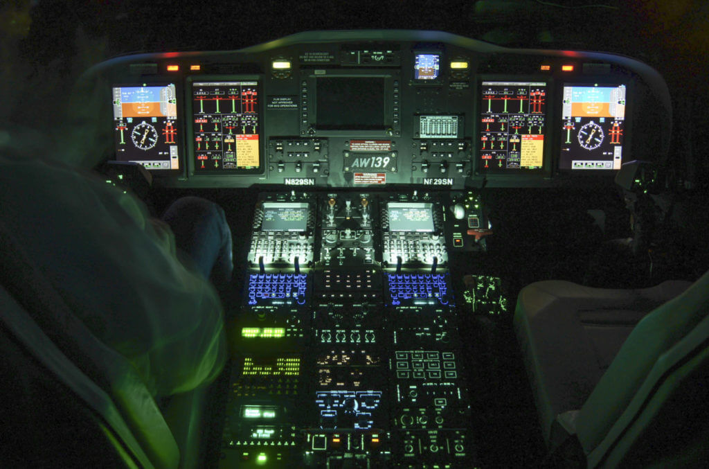 AW139 cockpit, dark, with instruments lit up.