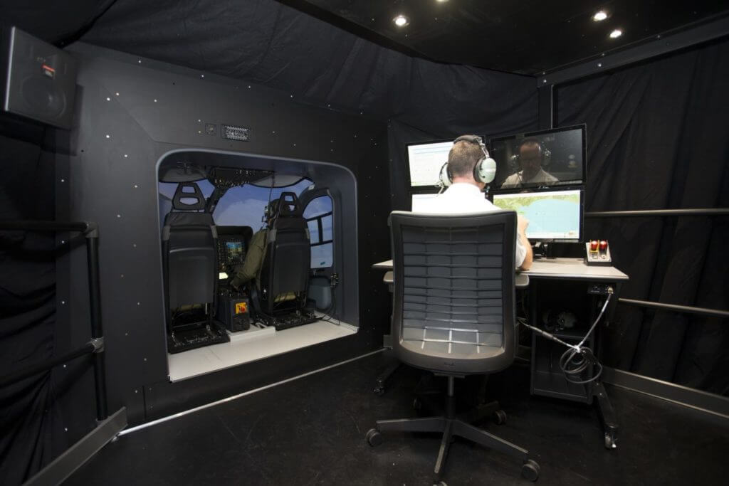 Interior view of simulator. Man sitting in front of screen.