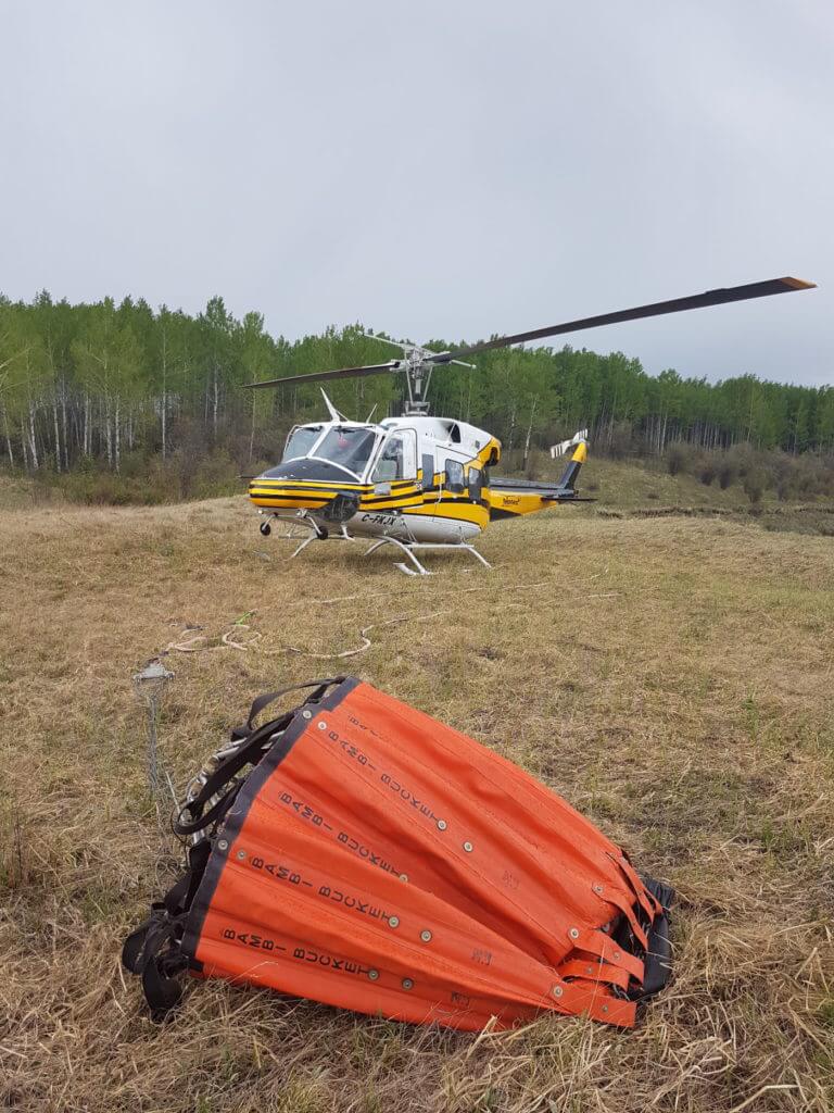 Here, a Yellowhead Helicopters Bell 212HP sits near Pink Mountain, British Columbia, with its Bambi Bucket. Yellowhead Helicopters Photo