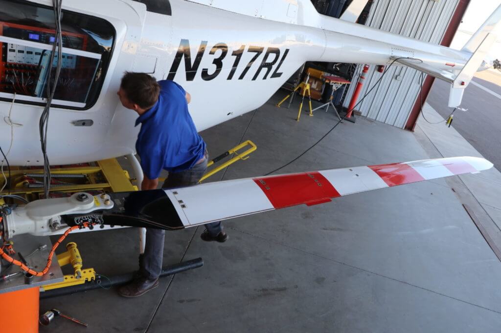 Flight test engineer Stephen Estes checks readings during calibration of an instrumented VHA 206L flight test blade. VHA Photo