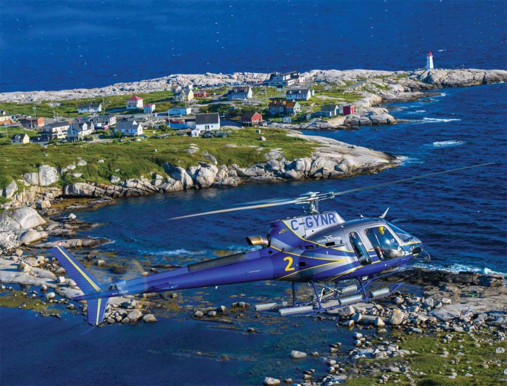 An Airbus H125 AStar, operated by Nova Scotia's Department of Lands and Forestry, Aviation Services, flies alongside the popular fishing village of Peggy's Cove in Nova Scotia. Mike Reyno Photo