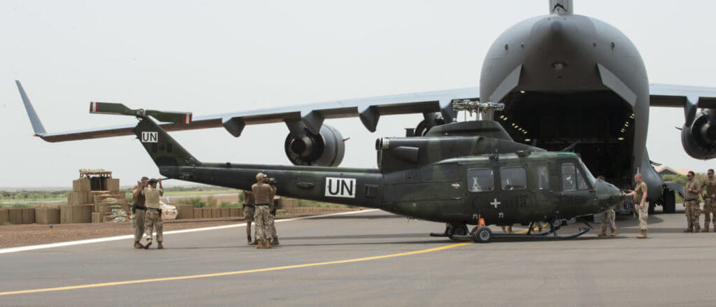 Members deployed on Operation PRESENCE-Mali offload a CH-146 Griffon helicopter after its arrival in Gao from a CC-177 Globemaster airplane on Aug. 25, 2018. Cpl Ken Beliwicz Photo