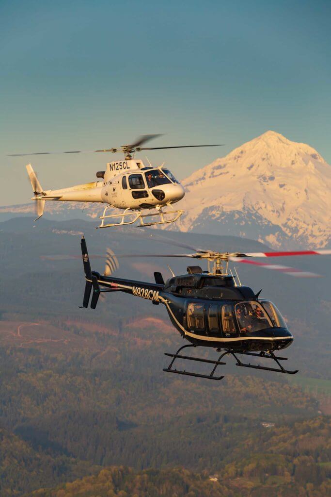 An Airbus H125 AStar and a Bell 407 fly together with Mount Hood in the background. The AStars are the latest additions to the Hillsboro fleet, and Lyons said the aircraft have been very well received by customers. Heath Moffatt Photo 