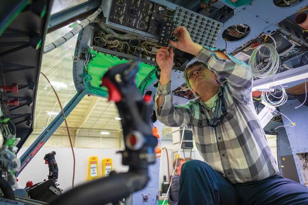 Aeronav Avionics' aircraft maintenance engineer Brent Butowski works on a wiring bus on a Bell 212 at Victoria International Airport. Heath Moffatt Photo