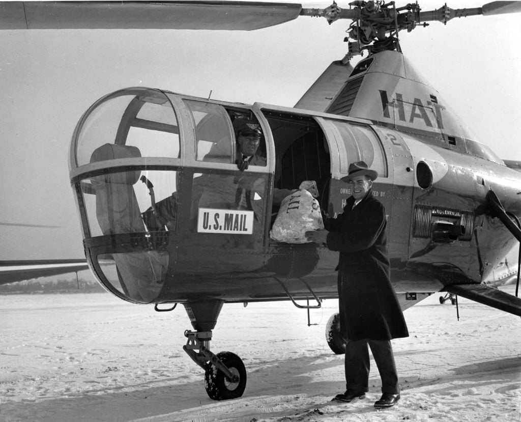 Chief pilot Frank Cashman of HAT watches as Gayle Sullivan from the U.S. Post Office loads mail on the Sikorsky S-51. HAT was the first commercial helicopter company to fly U.S. Post Office mail on an experimental flight. Jeff Evans Collection Photo