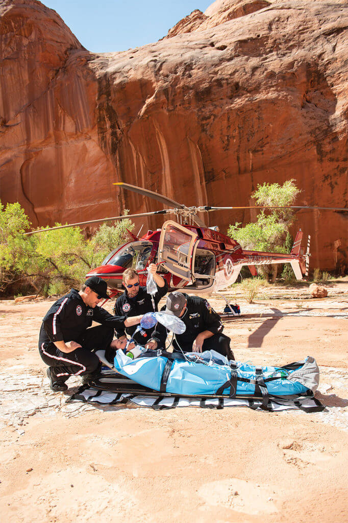 Chief pilot Adam West, left, assists flight nurse Keith Lepsch and paramedic Joe Root in an isolated canyon in the Glen Canyon National Recreation Area. Dan Megna Photo 