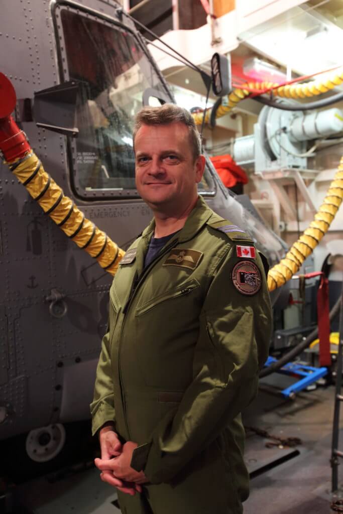 Maj Erik Weigelin stands with the Cyclone, wearing a badge on his arm that signifies the first CH-148 Cyclone to be deployed on an operational mission at sea. Patrick Dirksen and Frank Mink Photo