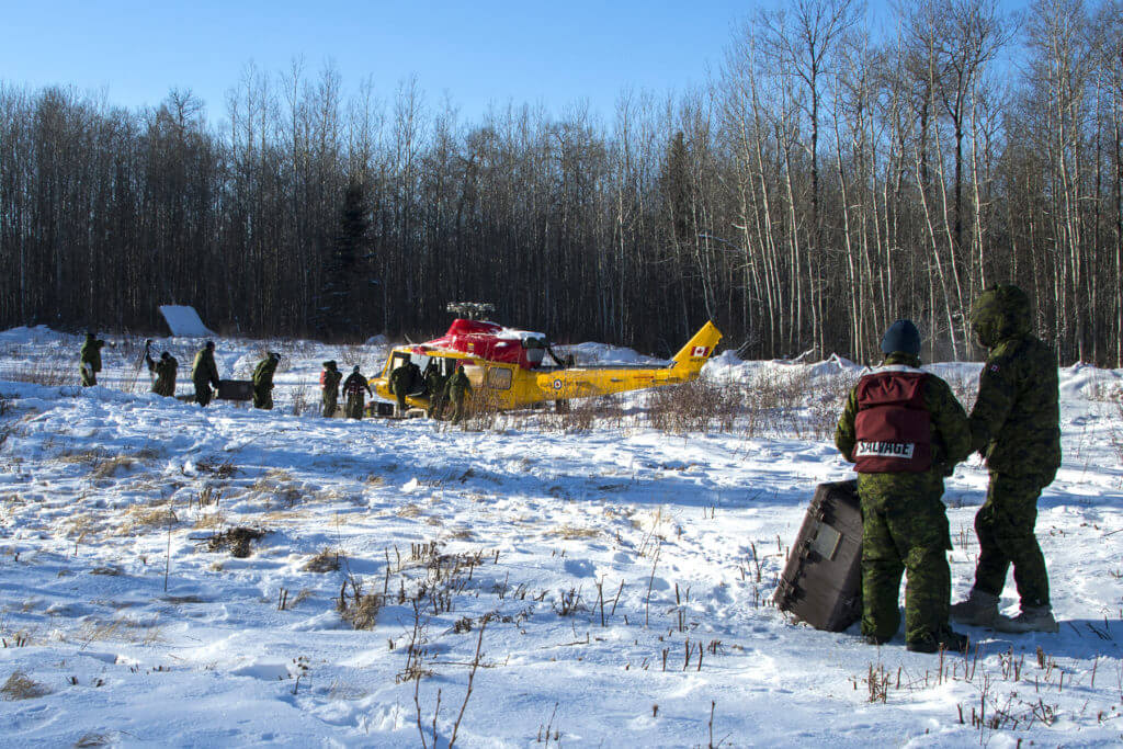 Members of 4 Wing Cold Lake's recovery and salvage team remove parts from a CH-146 Griffon that had an emergency landing in the Cold Lake Air Weapons Range in December 2018. They are shown preparing the Griffon for lift and recovery back to 4 Wing by a CH-147F Chinook helicopter from 450 Tactical Helicopter Squadron on Jan. 15, 2019. MCpl Raulley Parks Photo