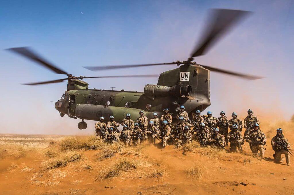 Members of Operation Presence-Mali pose for a group photo with a CH-147F Chinook at the small arms range near Gao in January. Cpl Ken Beliwicz Photo