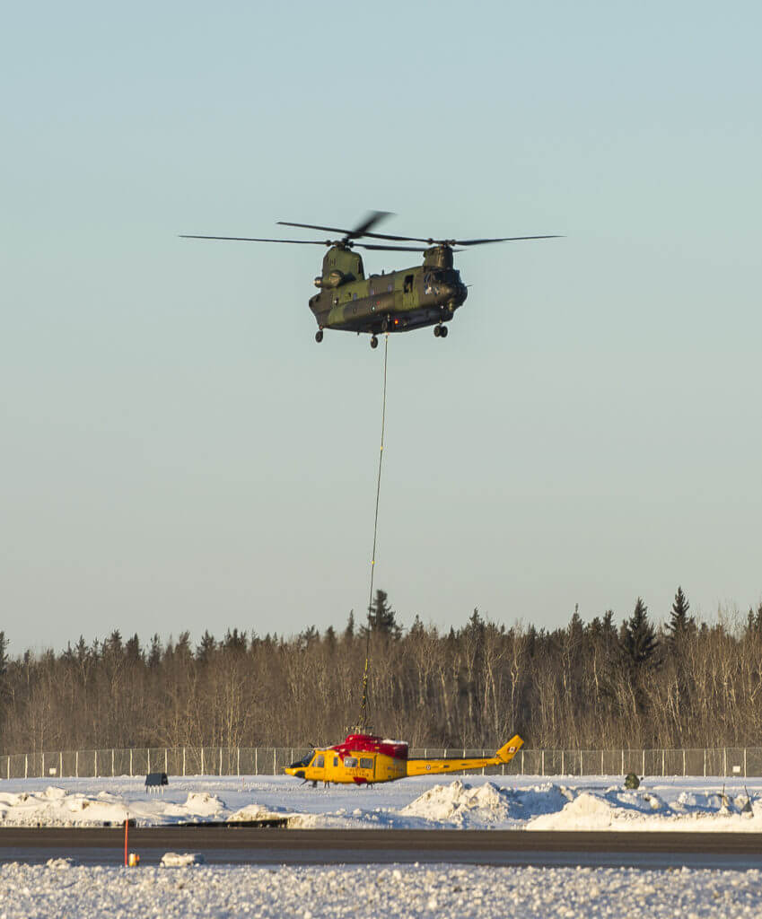 Almost there! The Chinook helicopter lowers the damaged Griffon beside the runway at 4 Wing Cold Lake after transporting it from a remote area of the Cold Lake Air Weapons Range. AB Mathieu Potvin Photo